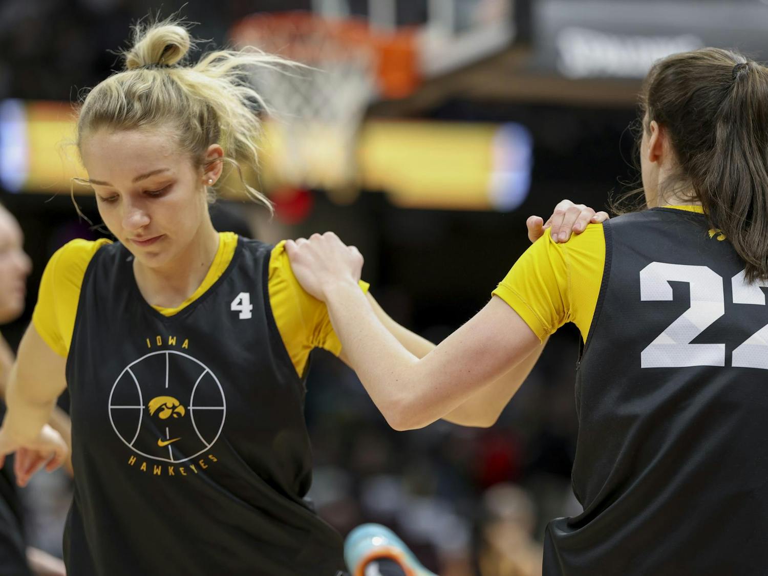 Hawkeye redshirt junior guard Kylie Feuerbach (left) and senior guard Caitlin Clark (right) use each other to balance during the team's dynamic warmup on April 6, 2024. The Hawkeyes defeated the University of Connecticut Huskies in the NCAA semifinal on Friday to advance to the national championship.