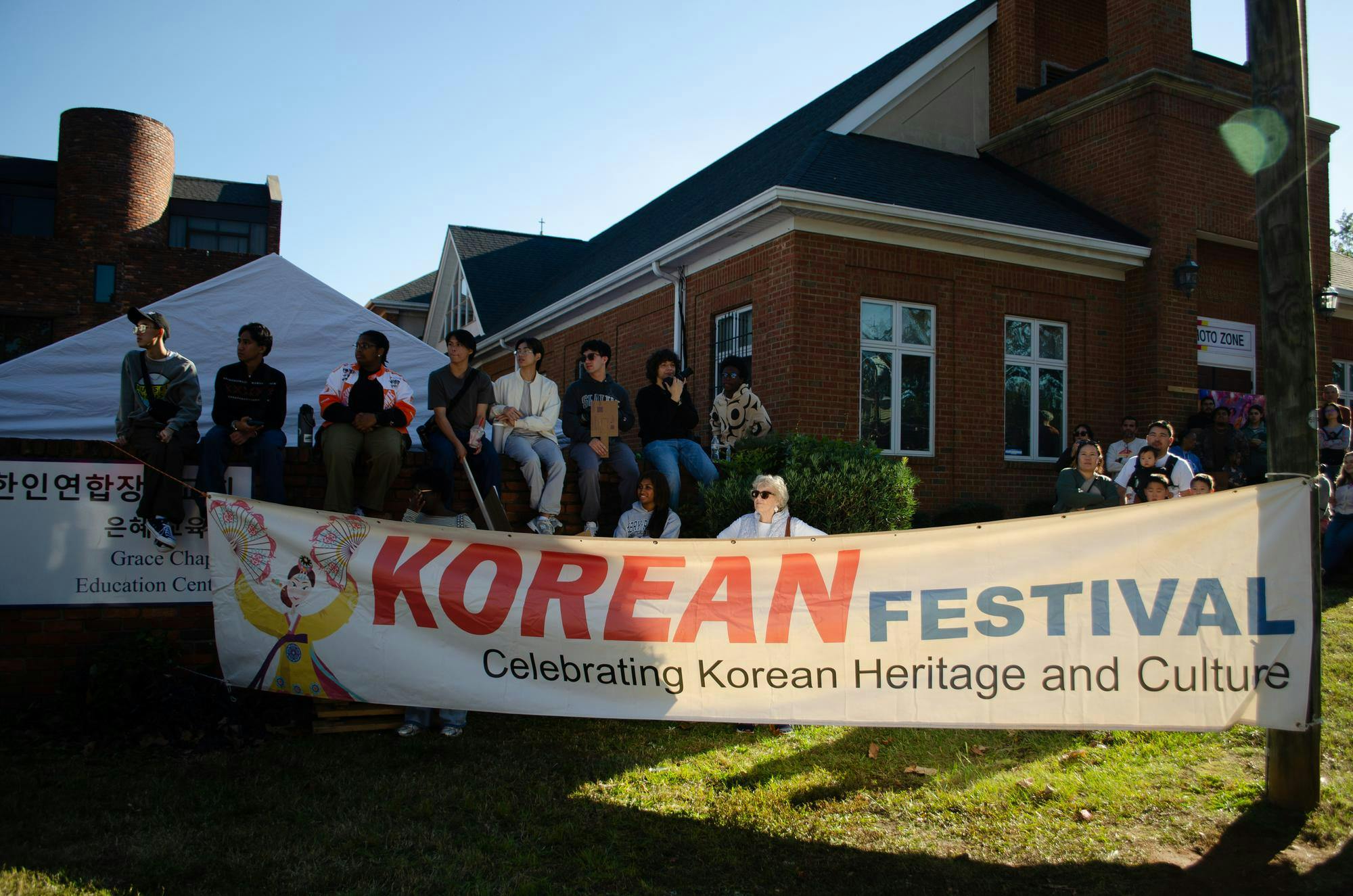 People watch performances at the Korean Festival at 1412 Richland St., Columbia, South Carolina on Nov. 1, 2025. They are in front of the Korean Community Presbyterian Church, who hosted the event.
