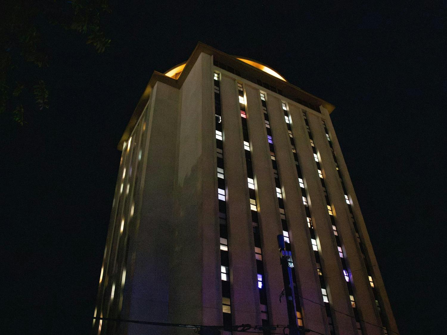 Lights glow from the windows of the Capstone building on the evening of April 2, 2025, creating a warm contrast on the night sky. The illuminated rooms reflect the late-night routines of college life.