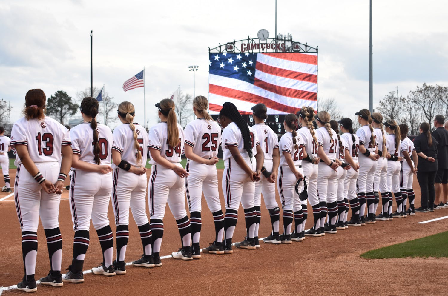The South Carolina softball team stands together during the Pledge of Allegiance at the start of its first game in the Carolina Classic against East Tennessee State on Feb. 16, 2023. The Gamecocks started the tournament with a 9-2 win over the Buccaneers.&nbsp;