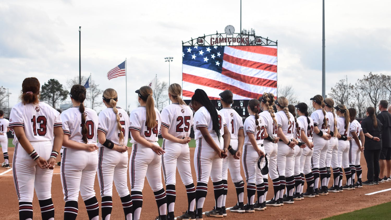 The South Carolina softball team stands together during the Pledge of Allegiance at the start of its first game in the Carolina Classic against East Tennessee State on Feb. 16, 2023. The Gamecocks started the tournament with a 9-2 win over the Buccaneers.&nbsp;