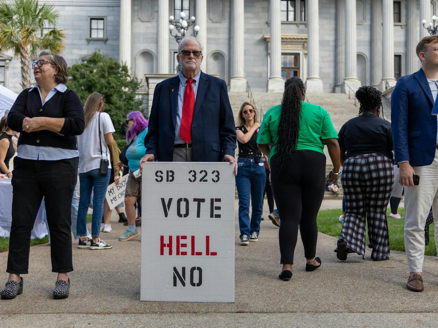 A man holds a sign reading "SB 323 VOTE HELL NO" at a rally against S.B. 323 on the lawn of the SC State House on Oct. 1, 2025. Columbia residents and people from all over South Carolina came to Columbia to either oppose or endorse the bill in a public hearing.