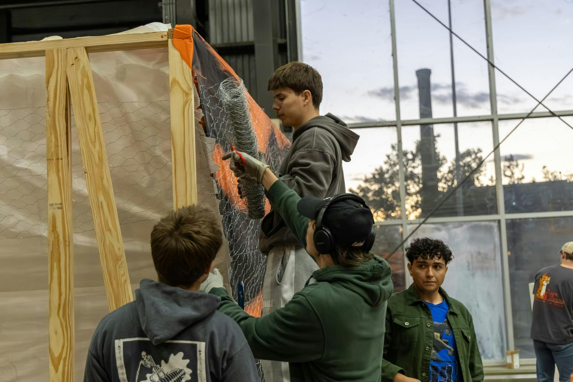 Third-year mechanical engineering student Bradley Wardell holds a roll of wire mesh while another student cuts it during the building of the Tiger Burn statue on Nov. 10, 2025. The American Society of Mechanical Engineers has been building the tiger statue for Tiger Burn for 22 years.