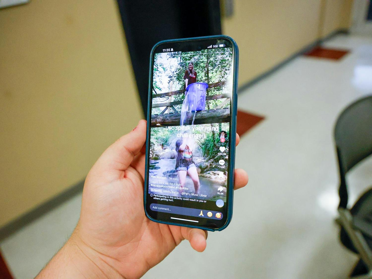 A phone playing a TikTok featuring a group of girls doing the "SpeakYourMind" ice bucket challenge. The challenge attempts to spread mental health awareness across social media platforms like TikTok and Instagram
