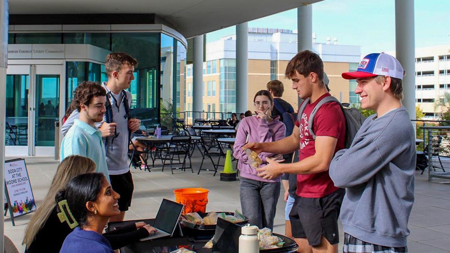 Student Government senators (left to right) Sreshta Ravi, Tyler Morgan and Patrick Koon talk to students in the breezeway outside of the Darla Moore School of Business on Oct. 24, 2023. The Student Government Food for Thought initiative asked students to share any ideas, complains or concerns they have with campus-related issues in exchange for chicken minis provided by Student Government.