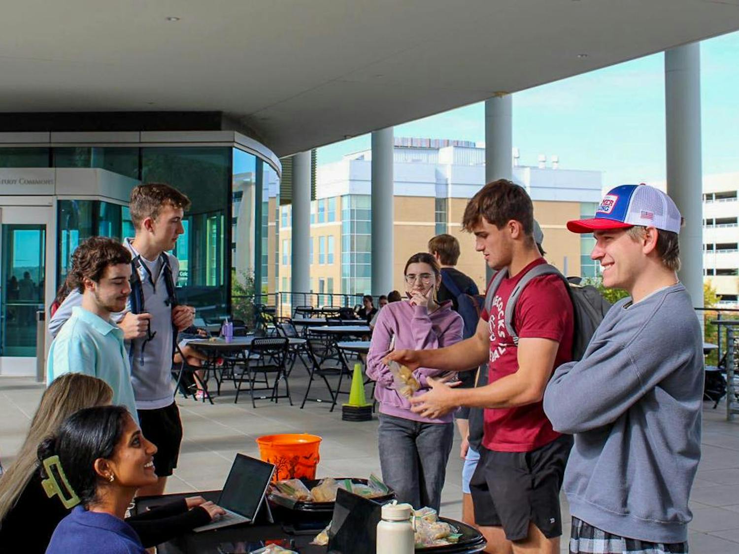 Student Government senators (left to right) Sreshta Ravi, Tyler Morgan and Patrick Koon talk to students in the breezeway outside of the Darla Moore School of Business on Oct. 24, 2023. The Student Government Food for Thought initiative asked students to share any ideas, complains or concerns they have with campus-related issues in exchange for chicken minis provided by Student Government.
