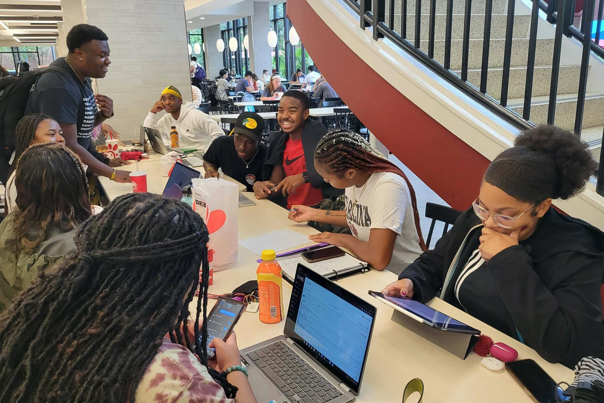 Black students gather around the community table on the first floor of Russell House on Aug. 25, 2022. Students gather on a daily basis, typically during lunch, to eat, work on homework and hang out with each other.