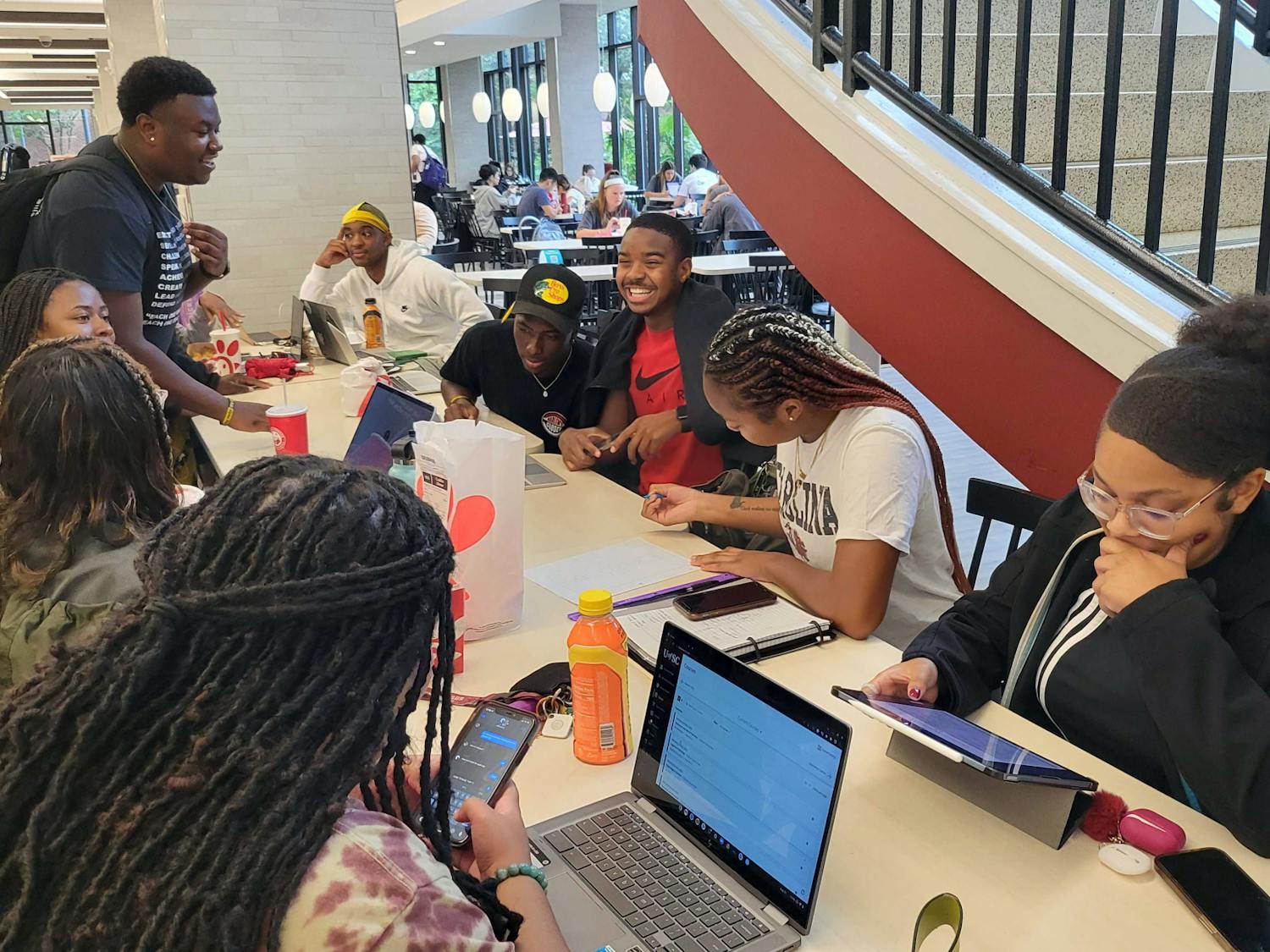 Black students gather around the community table on the first floor of Russell House on Aug. 25, 2022. Students gather on a daily basis, typically during lunch, to eat, work on homework and hang out with each other.
