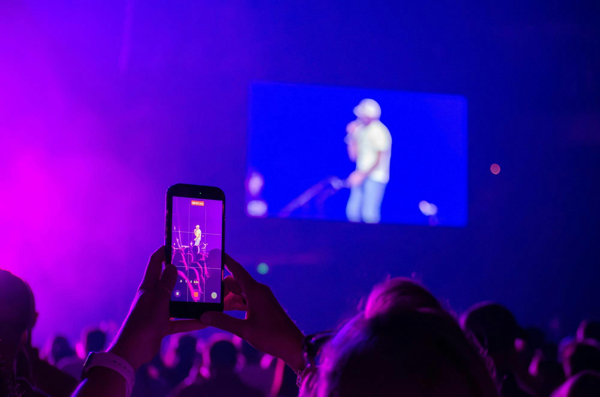 A woman records the performance of Darius Rucker at the Garnet &amp; Black Spring Fest at Colonial Life Arena in Columbia, South Carolina, on April 11, 2026. A native of Charleston, South Carolina, Rucker is the recipient of multiple Grammy awards.