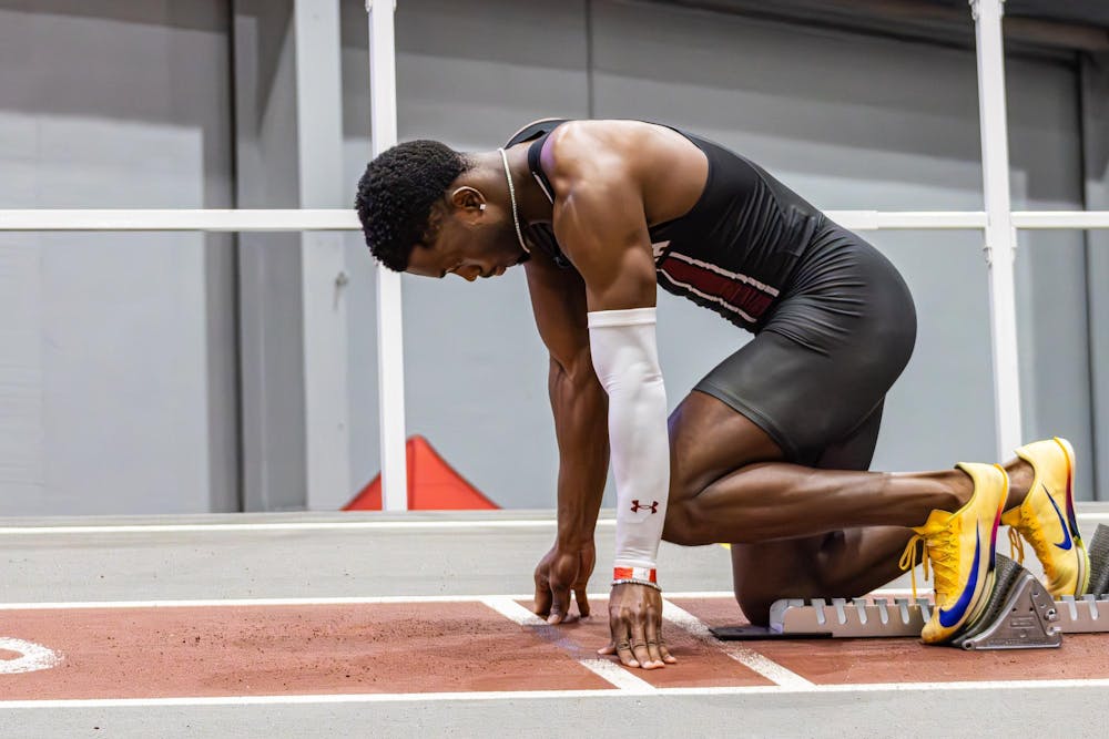<p>Junior sprinter Jasauna Dennis steps into his blocks as he gets ready to run the men’s 400 meter during the USC Invite indoor track meet on Feb. 21, 2026. He ran his best race of the season, finishing first with a time of 46.07.</p>
