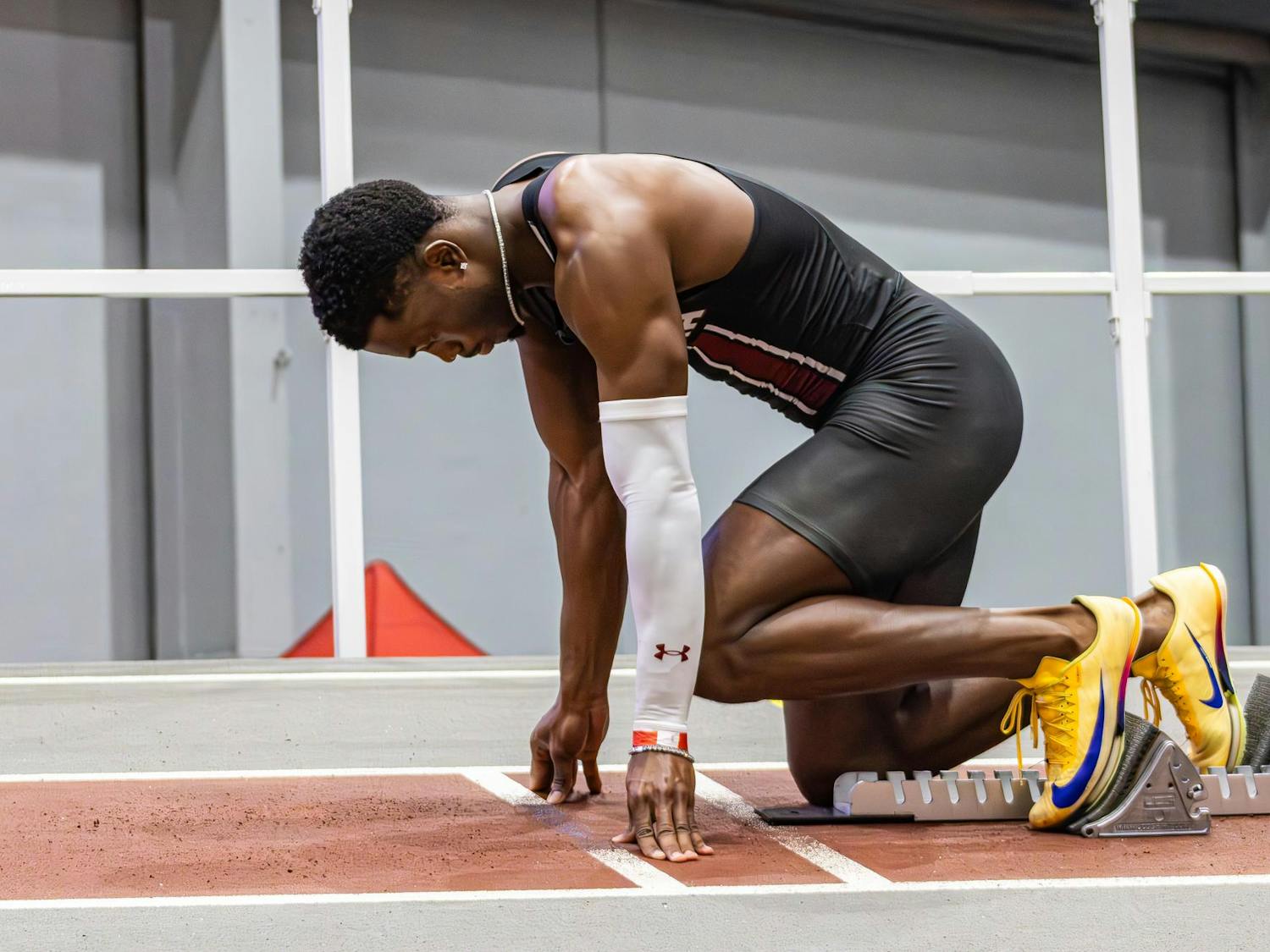 Junior sprinter Jasauna Dennis steps into his blocks as he gets ready to run the men’s 400 meter during the USC Invite indoor track meet on Feb. 21, 2026. He ran his best race of the season, finishing first with a time of 46.07.