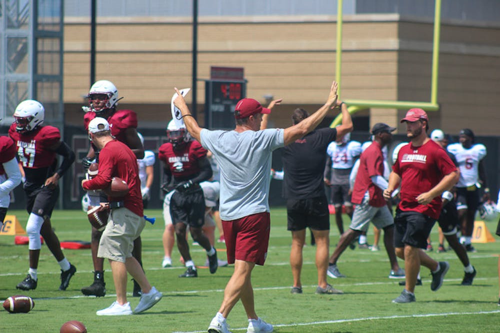 <p>Head football coach Shane Beamer calls out to the football team during practice on August 8, 2022.&nbsp;</p>