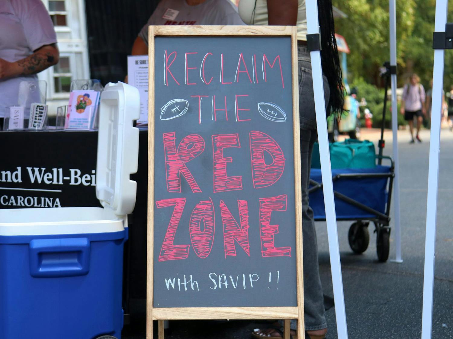 A sign reading “Reclaim the Red Zone with SAVIP” sits on Greene Street during the Carolina Kickoff event on Aug. 30, 2024. Multiple university organizations set up tables and tents to talk with students while they attended the event.