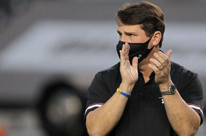 University of South Carolina football head coach Will Muschamp claps while walking down the sideline of the football game against the Tennessee Volunteers.