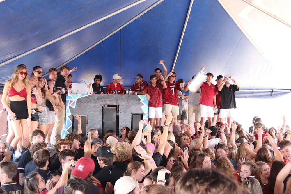 <p>FILE — University of South Carolina students gather under a tent at the Fraternity Lots, a popular tailgate location before home football games, on Oct. 2, 2021.</p>