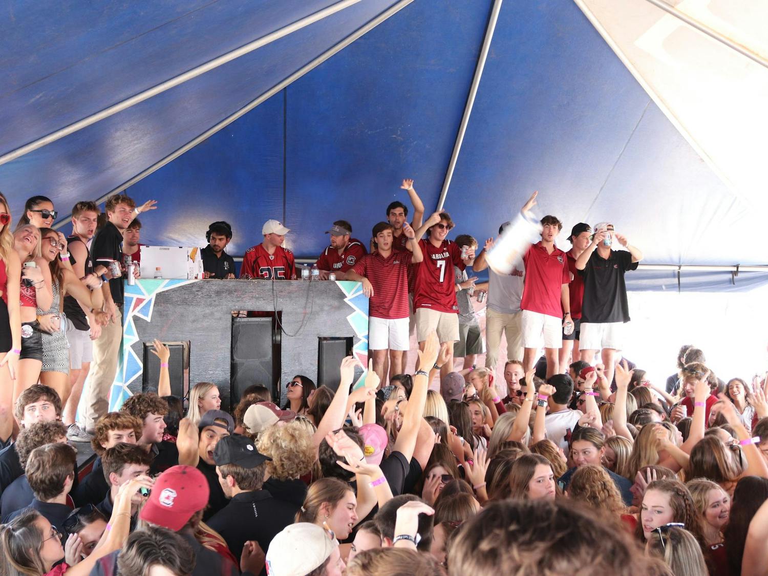 FILE — University of South Carolina students gather under a tent at the Fraternity Lots, a popular tailgate location before home football games, on Oct. 2, 2021.