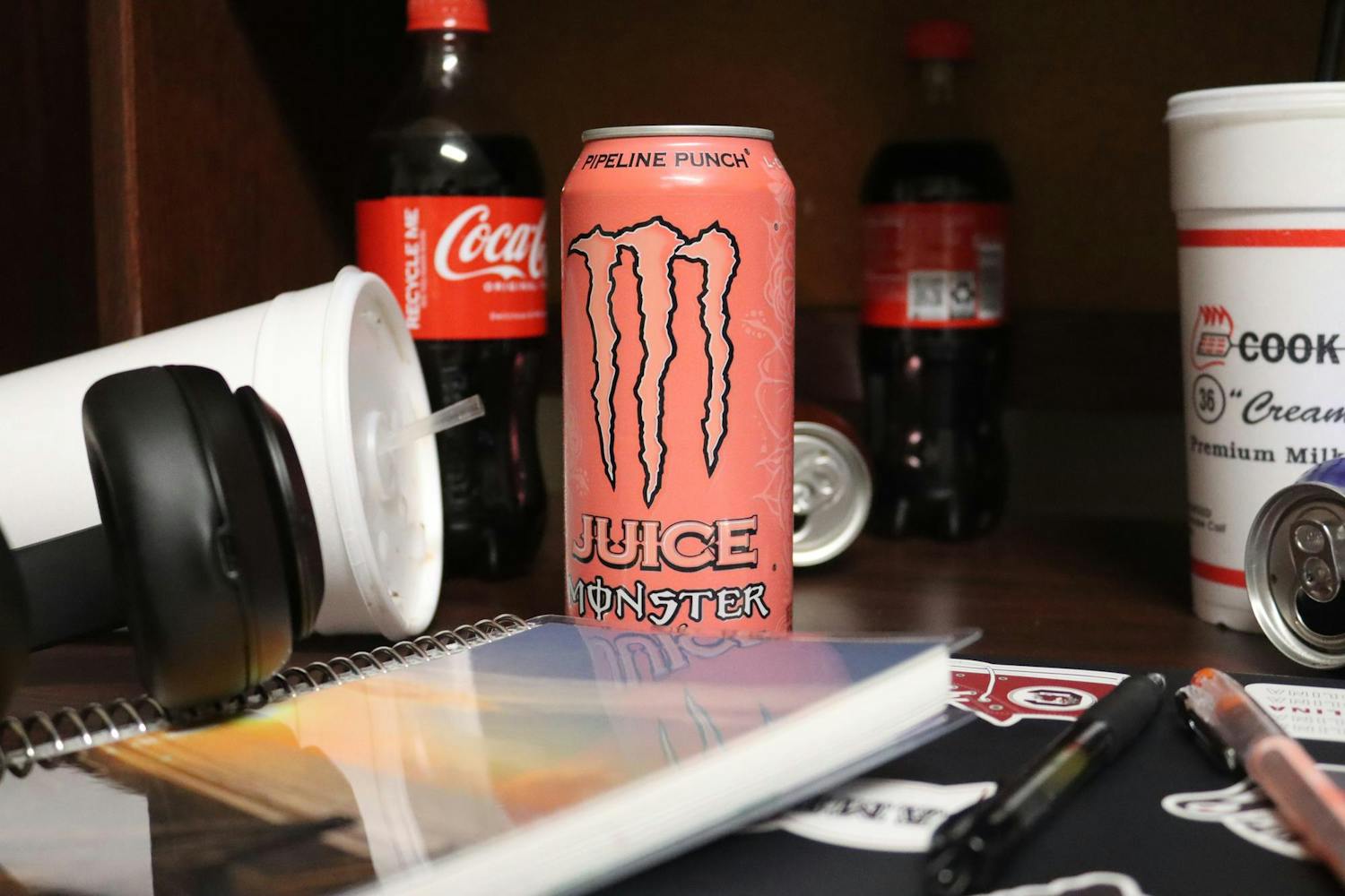 A photo illustration of a ɫɫƵ’s desk covered in caffeinated beverages on Jan. 14, 2024. One can of Monster Pipeline Punch contains 161 milligrams of caffeine.
