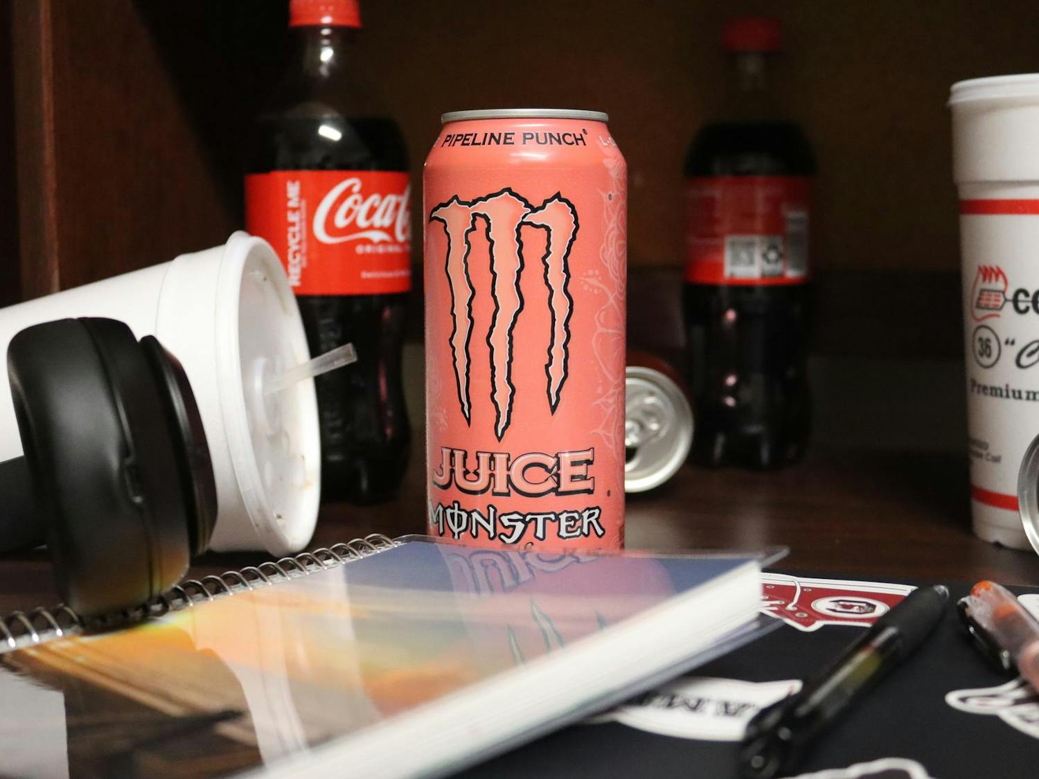 A photo illustration of a student’s desk covered in caffeinated beverages on Jan. 14, 2024. One can of Monster Pipeline Punch contains 161 milligrams of caffeine.