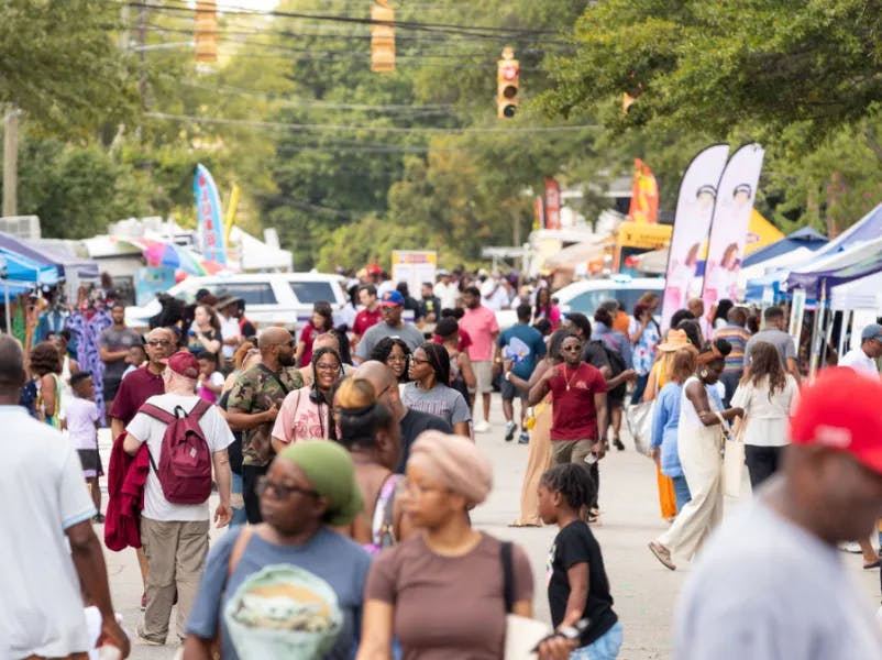 Crowds fill the street at a lively outdoor festival, with people exploring vendor tents, food stands and community activities. Jubilee 2025: Festival of Black History and Culture is a free, annual event presented by Historic Columbia on Saturday, Sept. 20, 2025, from 11 a.m. to 6 p.m. at the Mann-Simons Site in Columbia, SC.