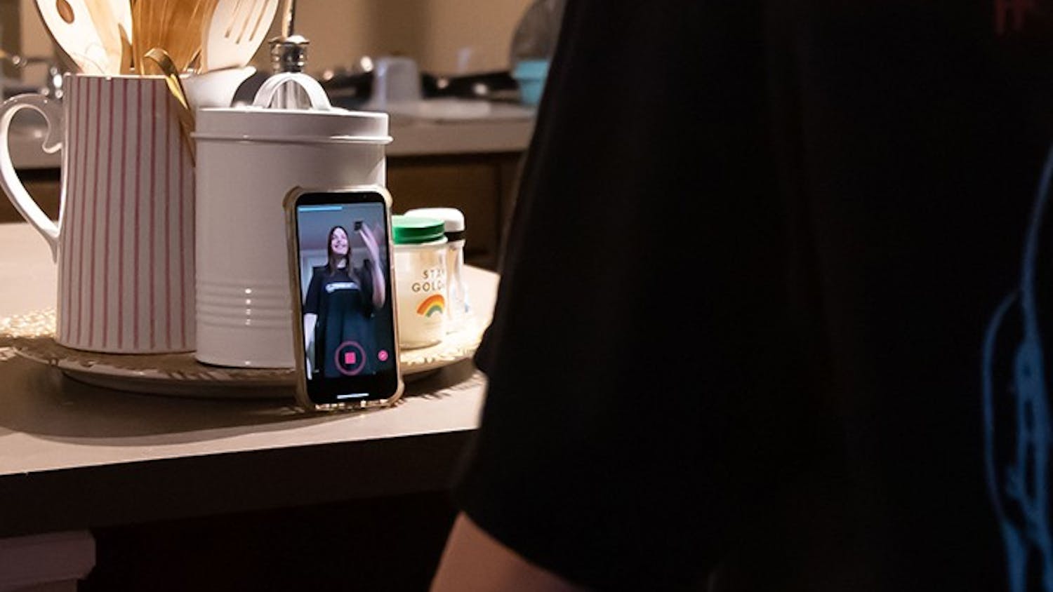 A person stands in front of their phone while doing the dance trend for the TikTok sound “Ski Mask the Slump God - Foot Fungus.” 
