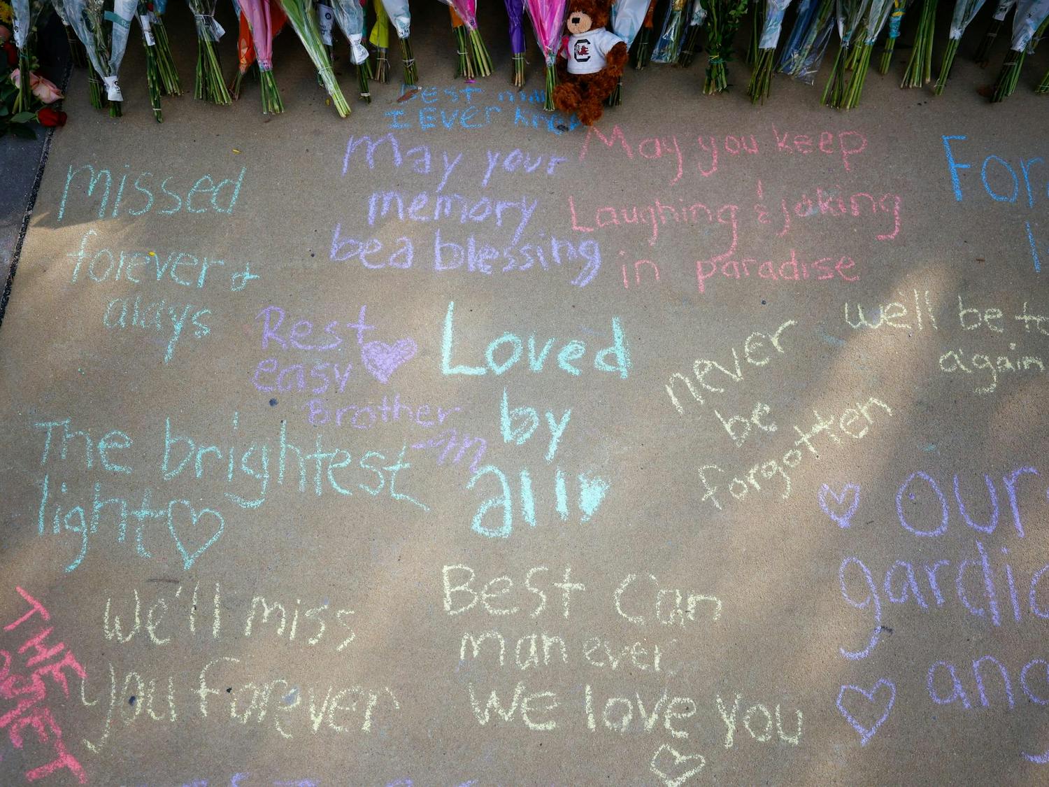 Various chalk messages populate the sidewalk outside the memorial for Nathaniel "Nate" Baker on April 3, 2025. Students left messages and flowers at the site in memory of Baker, who was killed in a hit-and-run the previous day outside Strom Thurmond Wellness and Fitness Center.