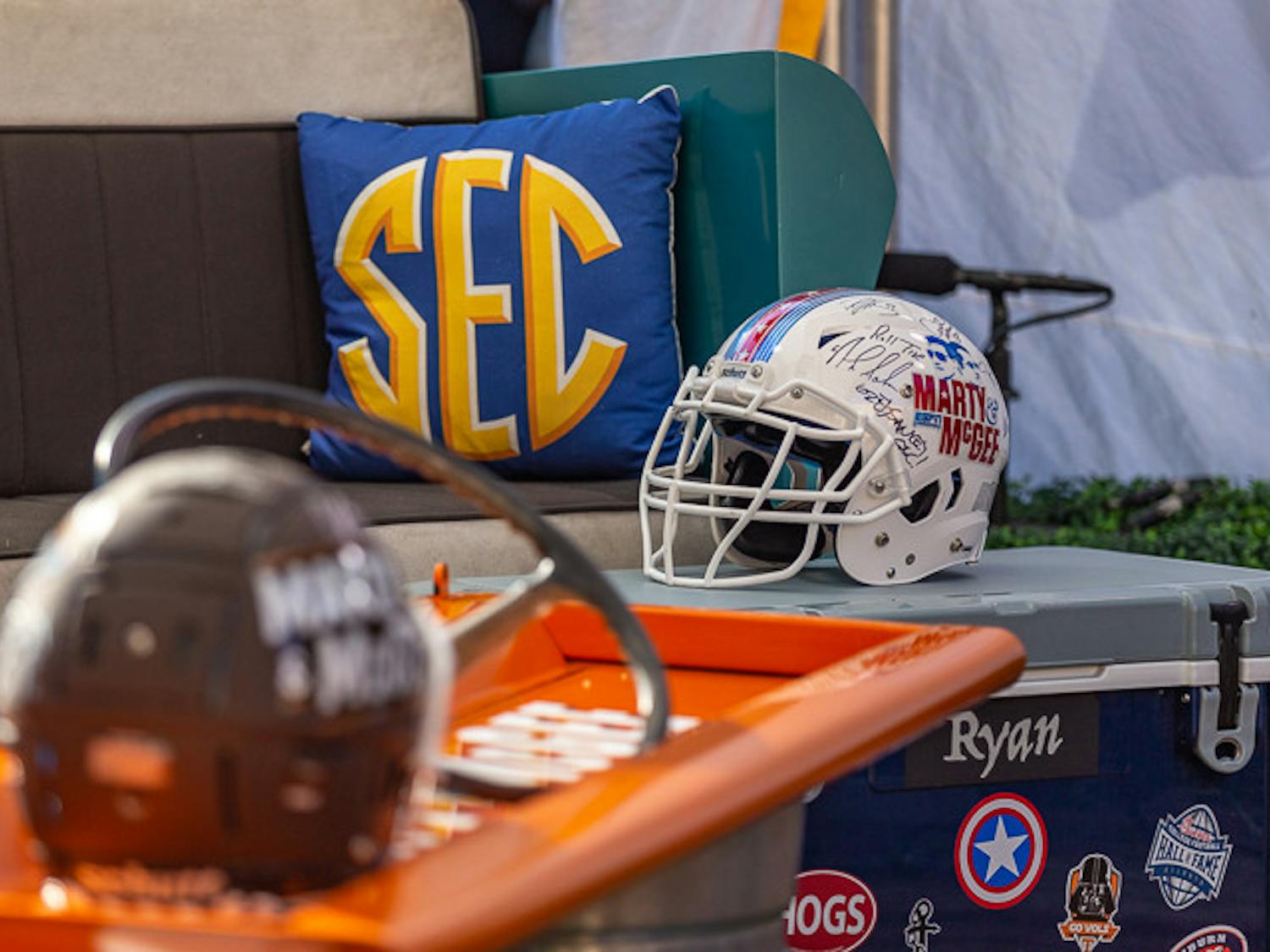 Signed helmets from coaches and platers sit in the Marty &amp; McGee tent on Nov. 19, 2022. The pregame show travels each week to SEC campuses to discuss upcoming games and interview players, coaches, and staff.