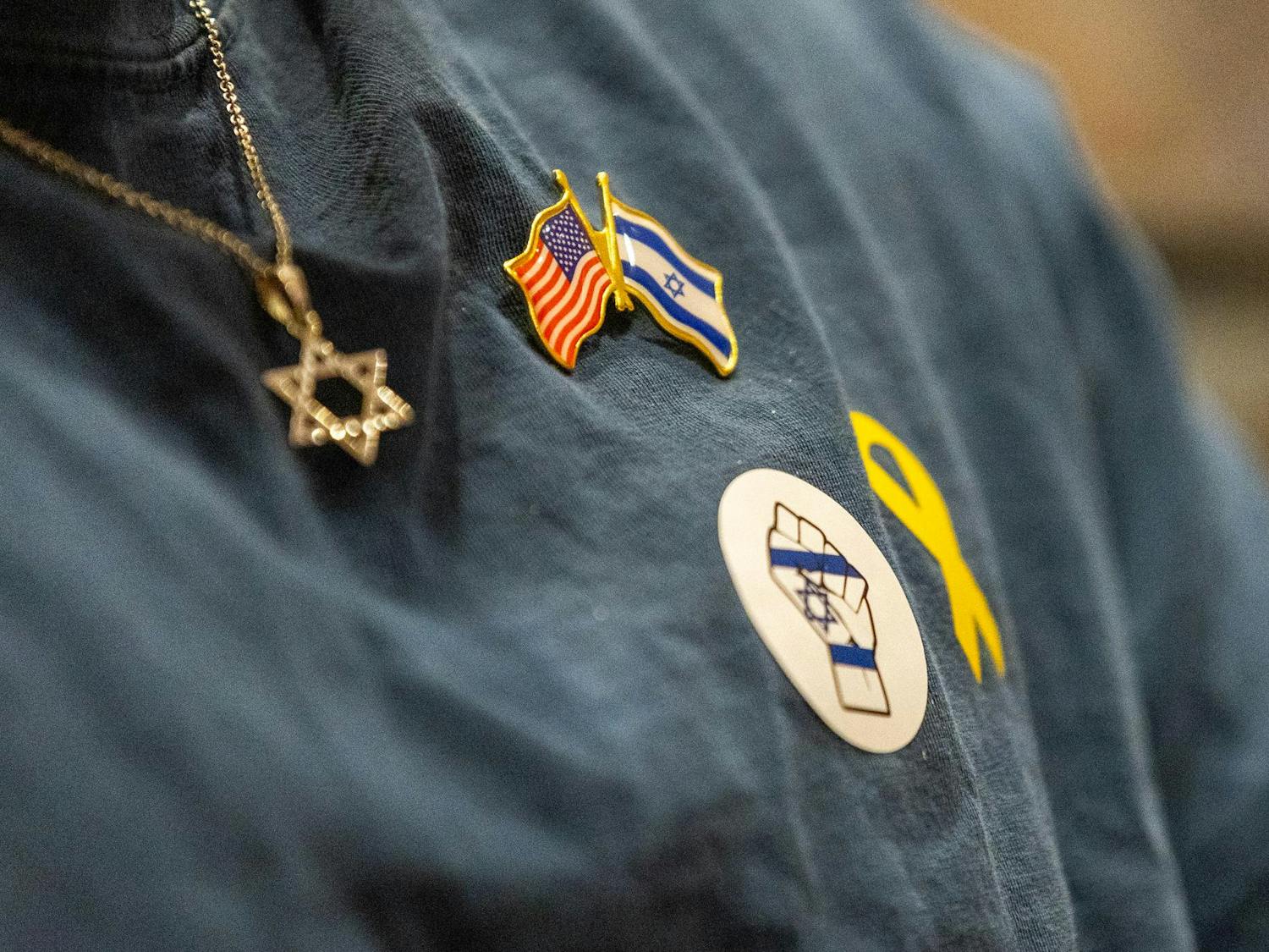 A member of Gamecocks for Israel wears the Star of David amongst pins and stickers, demonstrating support for Israel during the Israel Solidarity Rally hosted by Gamecocks for Israel on Oct. 7, 2024. Members of the student organization Gamecocks for Israel organized and attended the rally in commemoration of the attack on Israel on Oct. 7, 2023.