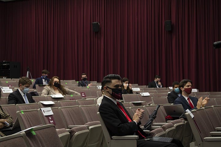 Student senate members clap as student senator Morgianna McDevitt reads off how many students have gotten their flu shot this semester.