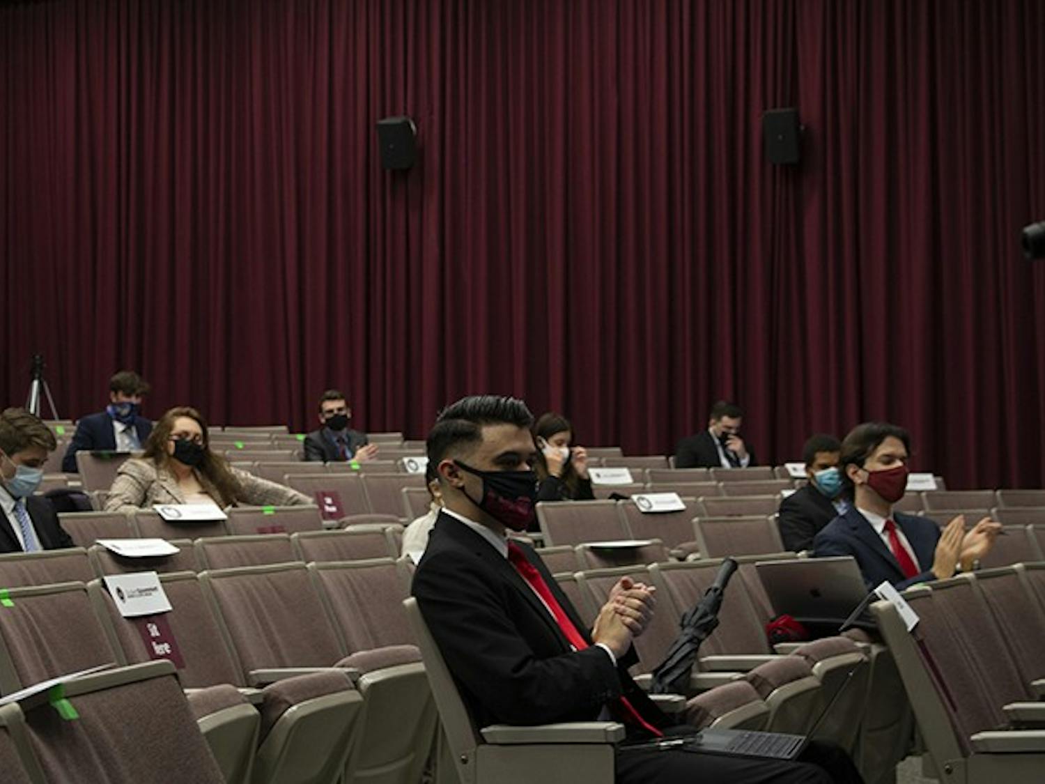 Student senate members clap as student senator Morgianna McDevitt reads off how many students have gotten their flu shot this semester.