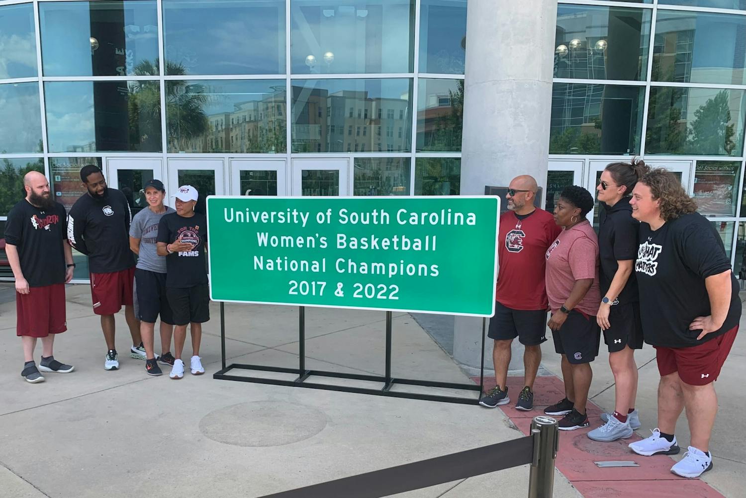 Women's basketball coach Dawn Staley and her coaching staff stand by a newly unveiled highway sign on June 23, 2022. The signs will be placed throughout South Carolina to commemorate the Gamecock's national championship win.&nbsp;
