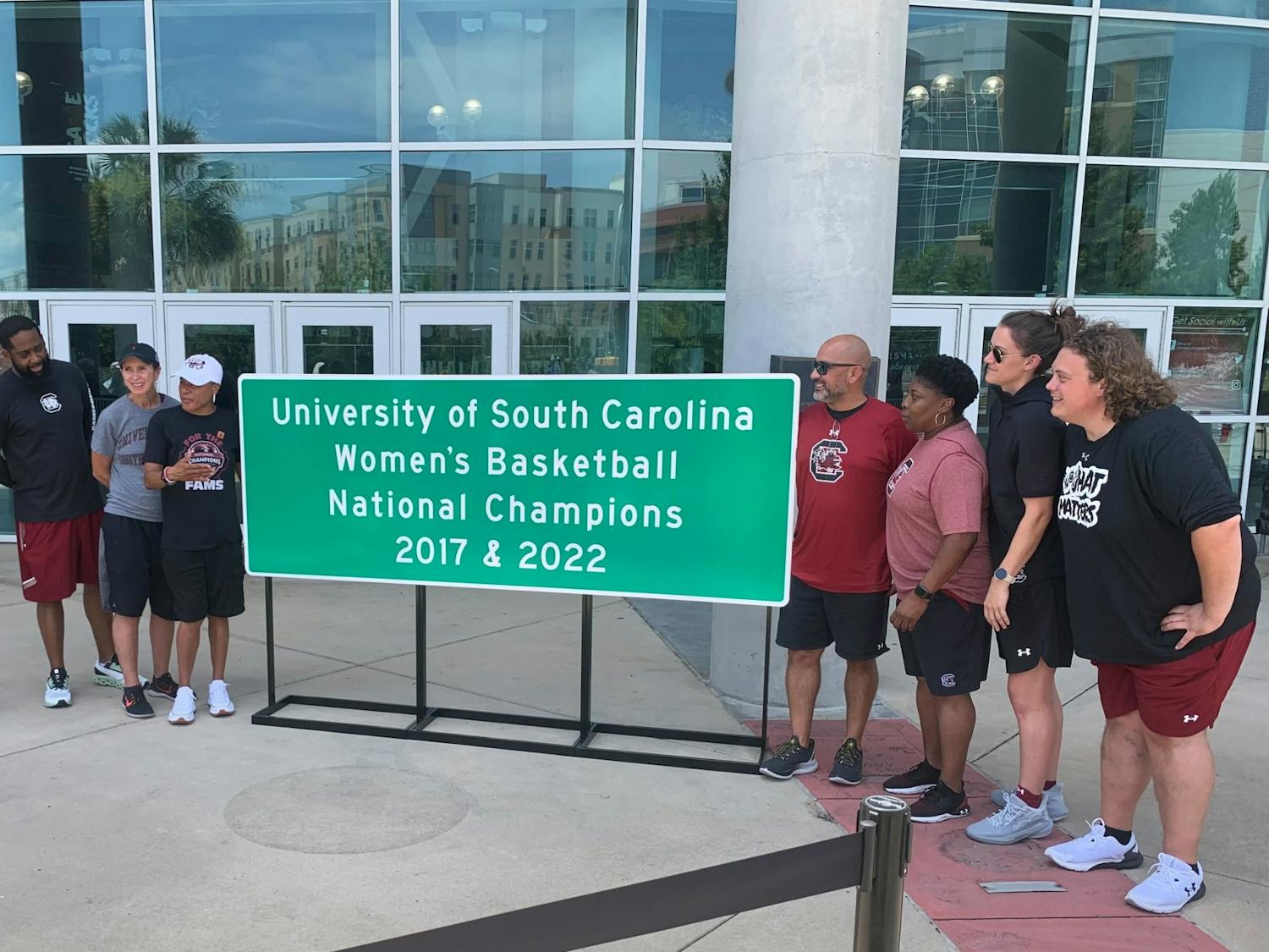 Women's basketball coach Dawn Staley and her coaching staff stand by a newly unveiled highway sign on June 23, 2022. The signs will be placed throughout South Carolina to commemorate the Gamecock's national championship win. 