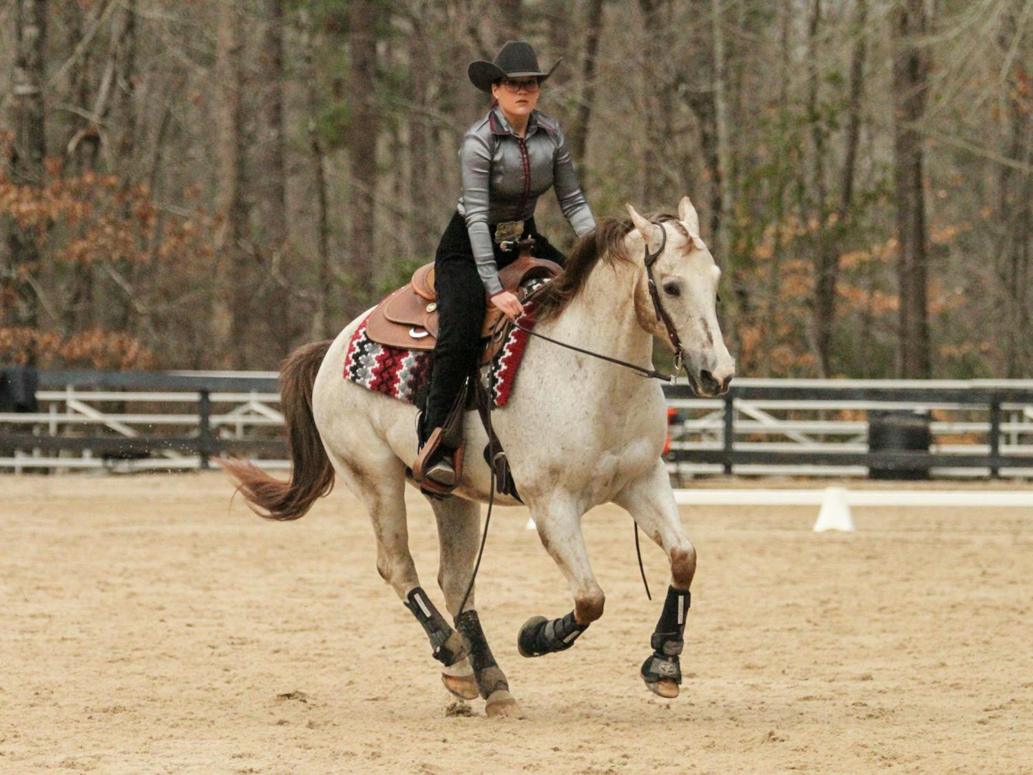 Senior Claire Pound, mounted on Paddy, demonstrates the pattern for the reigning category during the meet against Texas A&amp;M at One Wood Farm on Feb. 11, 2023. Pound, who has been showing horses from a young age, said that her teammates are what she will miss the most about competing on the collegiate level. “We’re a pretty small team compared to other NCEA teams," Pound said. "I think its super special. We’re all just honestly like 36 best friends, and I’m going to miss them so much, I can’t even explain it.”