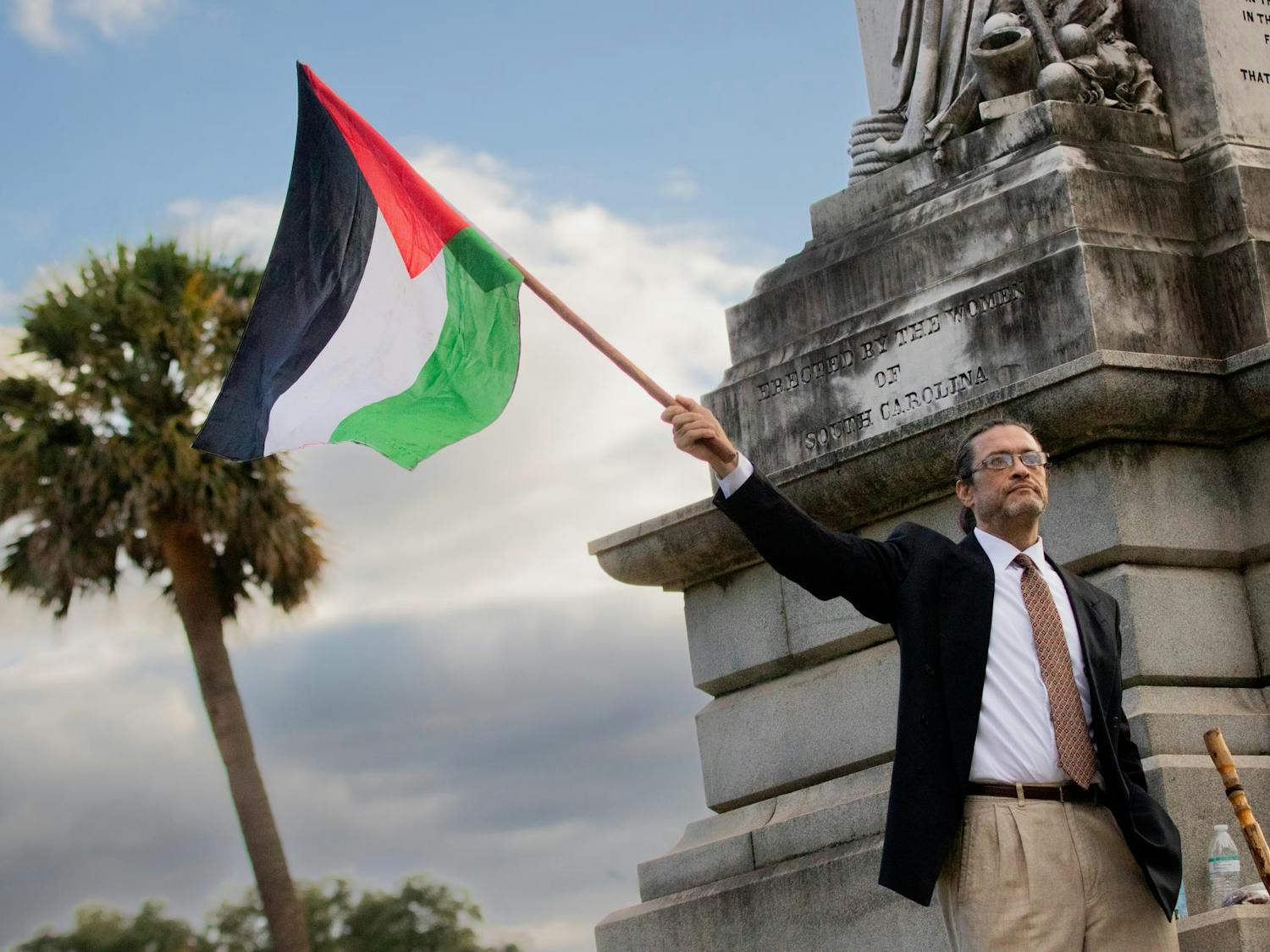 A Free Palestine Emergency Demonstration attendee raises a Palestinian flag in support. The rally was held by the North and South Carolina Party for Social Liberation at the South Carolina Statehouse on Oct. 17, 2023.
