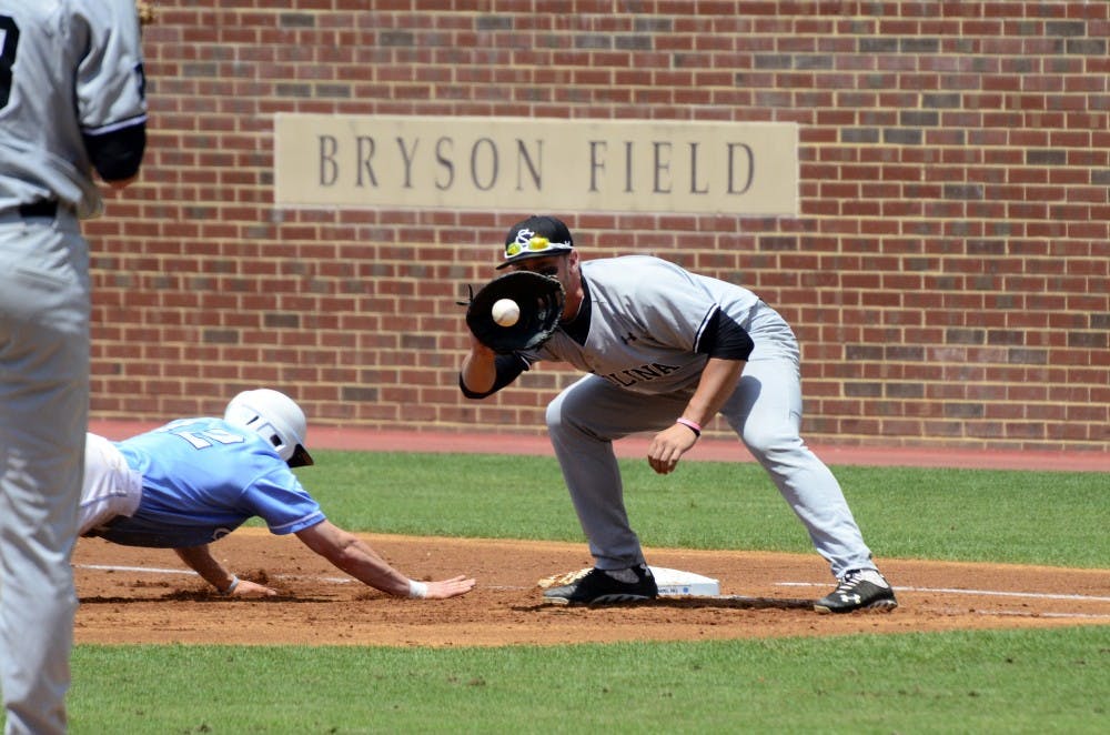 Kyle Martin tries to tag a runner out at first base.