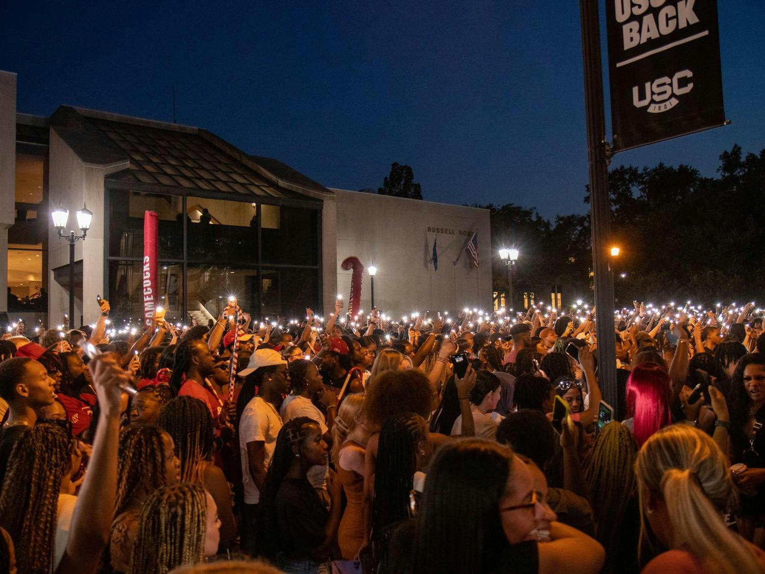 Students turn on their flashlights and wave their phones to music while DJ iAM performs during First Night Carolina on Aug. 23, 2023. DJ iAM played a mix of rap, hip-hop and R&amp;B hits.