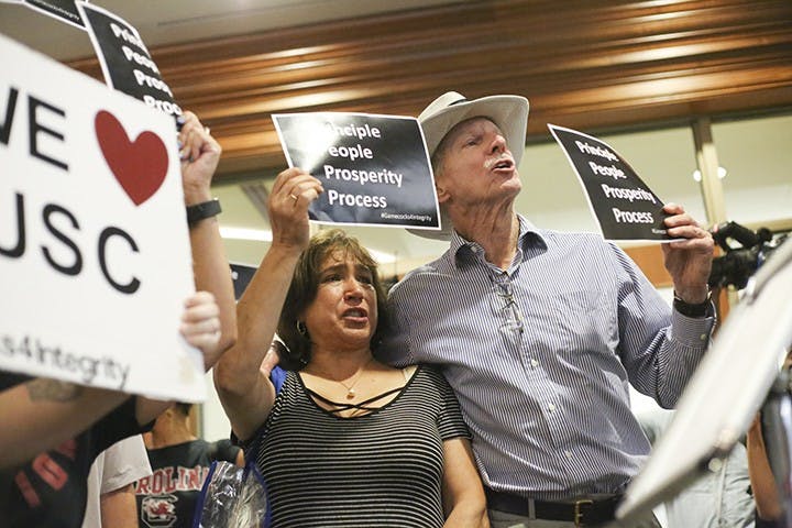 Protestors respond to the Board's announcement chanting "Shame" as the trustees leave.&nbsp;