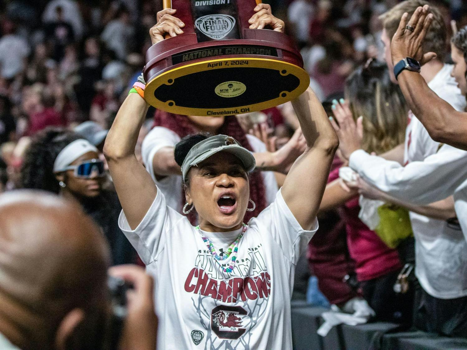 Head coach Dawn Staley hoists the NCAA Women's National Championship trophy over her head as she and her team greet fans following a welcome home celebration for the South Carolina Women's Basketball team at Colonial Life Arena on April 8, 2024. Staley has led the Gamecocks to three National Championship titles since 2017.