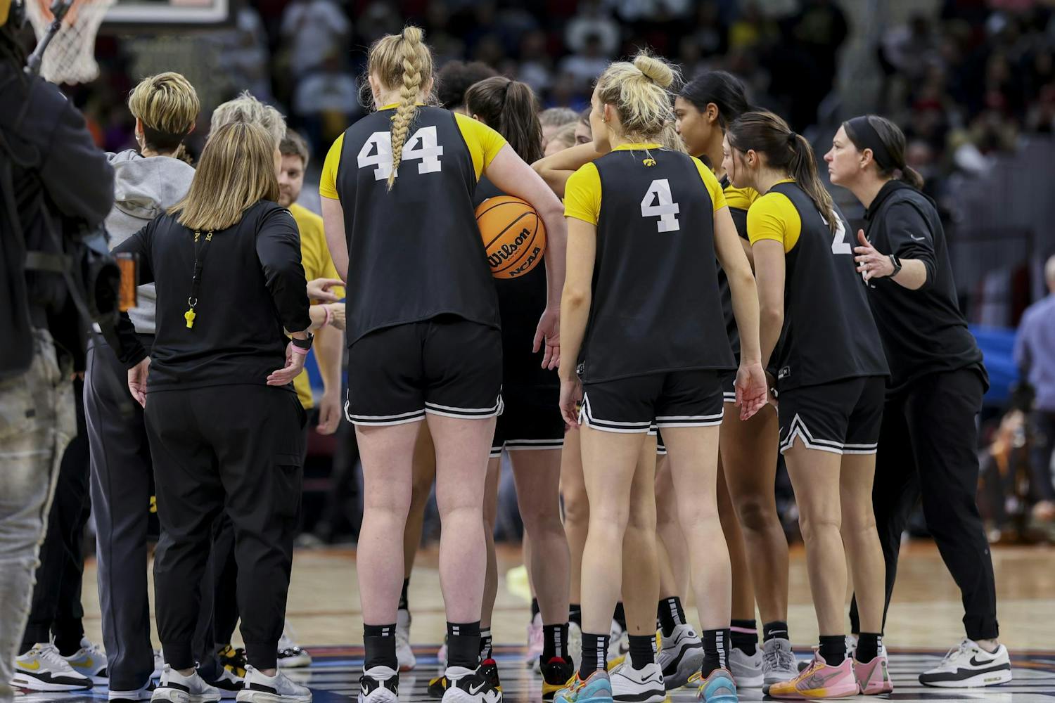 The Iowa Hawkeyes women's basketball team huddles in the center of the court in Rocket Mortgage FieldHouse on April 6, 2024. Following a team huddle, the team walked over to the spirit section and high-fived members of the Iowa Pep Band.