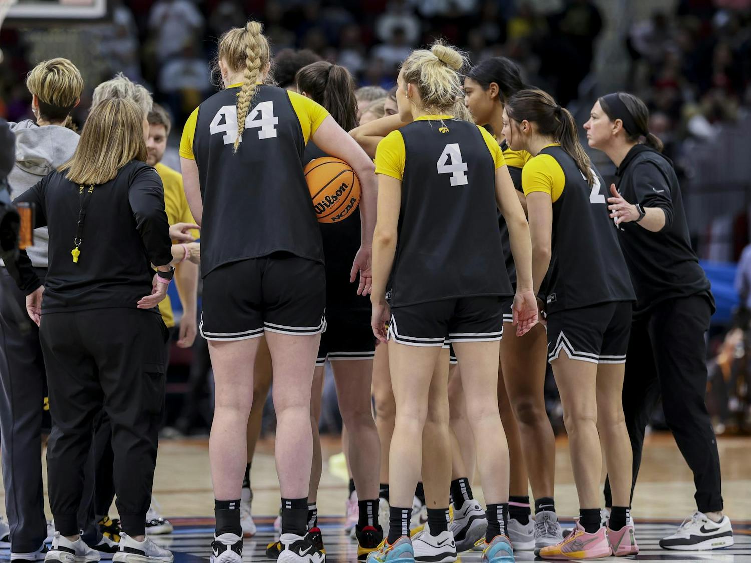 The Iowa Hawkeyes women's basketball team huddles in the center of the court in Rocket Mortgage FieldHouse on April 6, 2024. Following a team huddle, the team walked over to the spirit section and high-fived members of the Iowa Pep Band.