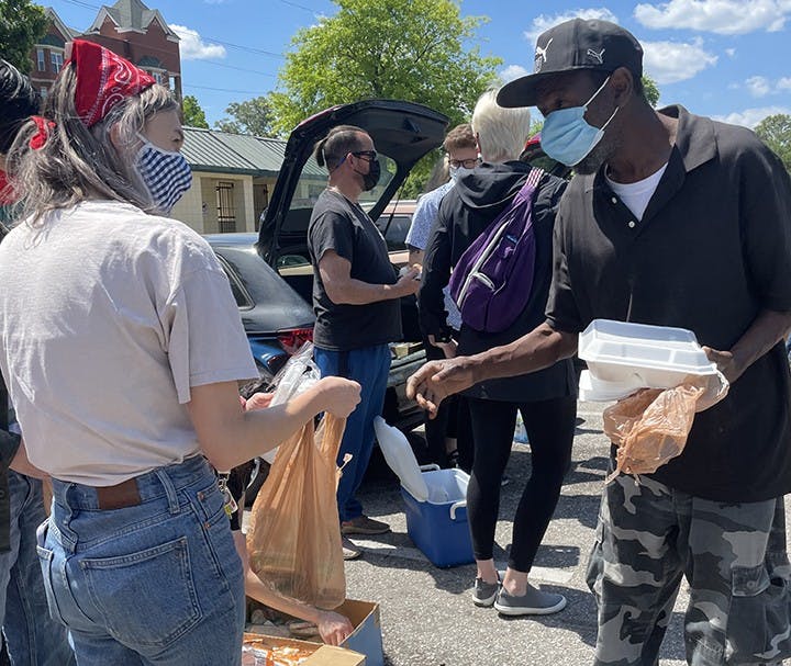 Second-year journalism student Charlotte Morrison distributing food at Finlay Park to the homeless population.