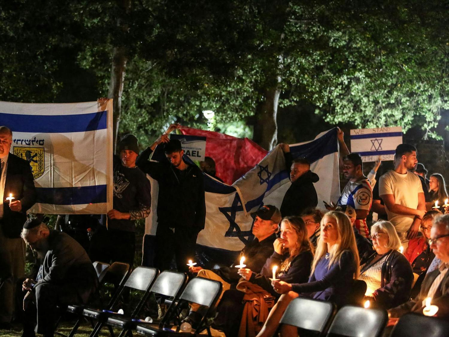 Attendees hold up the flags of Israel and Jerusalem in attempt to block attendeees holding up a large Palestinean flag during a Jewish community vigil in the garden of the Anne Frank Center at the University of South Carolina on Oct. 17, 2023. The vigil was hosted by Gamecocks for Israel, Hillel at UofSC, Alpha Epsilon Pi, Chabad on Campus and the University of South Carolina.