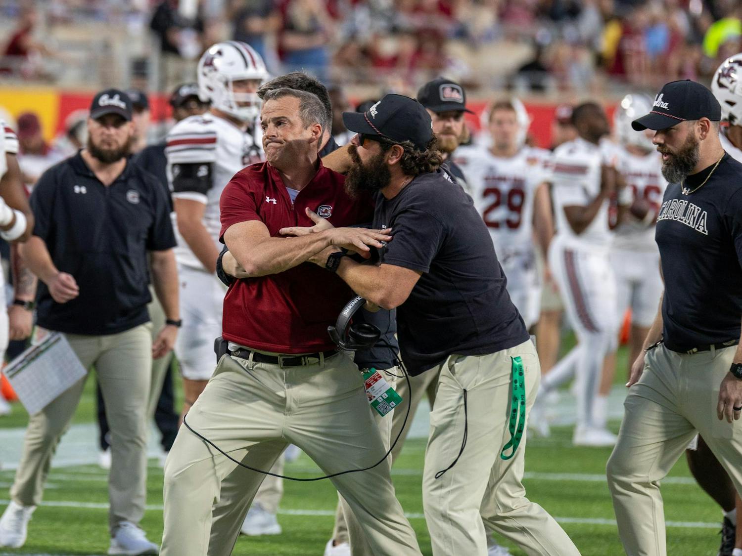 Head coach Shane Beamer (center, red shirt) is held back by assistant coaches after running toward Illinois head coach Bret Bielema during the Cheez-It Citrus Bowl on Dec. 31, 2024. Beamer later claimed that Bielema taunted South Carolina players after checking on an injured Illinois player, which led to the outlash.