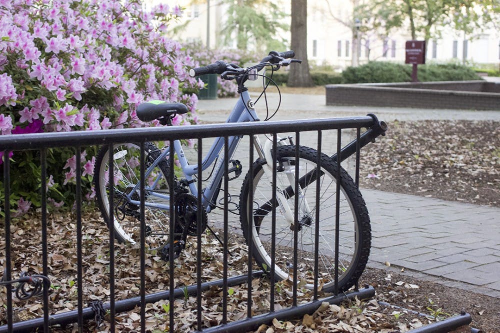 Bikes flagged with neon green stickers in a bike rack outside of the McClintock building in Women's Quad.