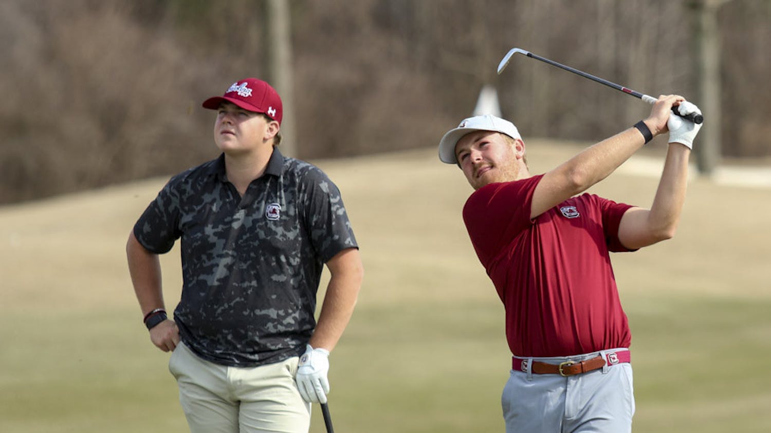 Fifth-year golfer Evans Lewis (on left) and redshirt senior golfer Lansdon Robbins (on right) watch the ball after Robbins wedges it off the green during practice on Feb. 8, 2023. Robbins transferred to South Carolina from UNC Wilmington this year after placing second on the team in low strokes and being named a member of the Colonial Athletic Association Conference’s Second Team for back-to-back years in 2021 and 2022.&nbsp;
