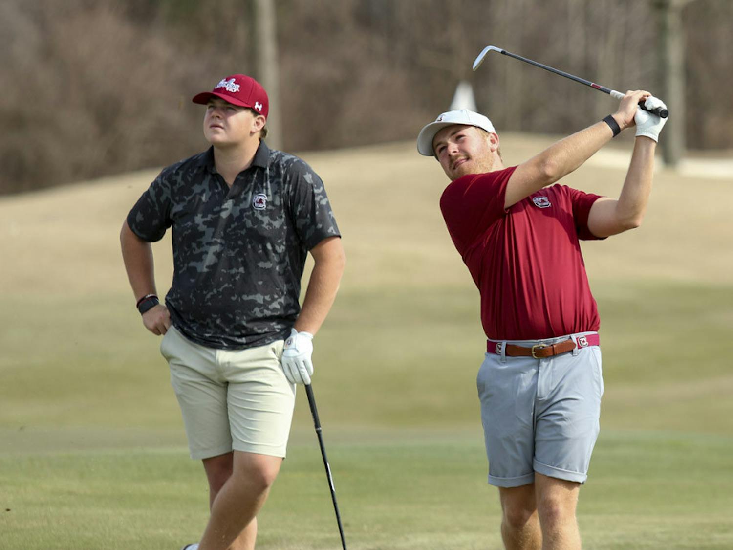 Fifth-year golfer Evans Lewis (on left) and redshirt senior golfer Lansdon Robbins (on right) watch the ball after Robbins wedges it off the green during practice on Feb. 8, 2023. Robbins transferred to South Carolina from UNC Wilmington this year after placing second on the team in low strokes and being named a member of the Colonial Athletic Association Conference’s Second Team for back-to-back years in 2021 and 2022.&nbsp;