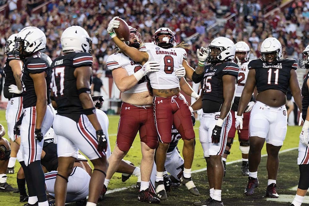 Graduate running back Christian Beal-Smith is lifted by redshirt senior offensive lineman Wyatt Campbell after making a touchdown for the Garnet team during the annual spring football game at Williams-Brice Stadium on April 16, 2022. The Garnet team defeated the Black team 20-13.