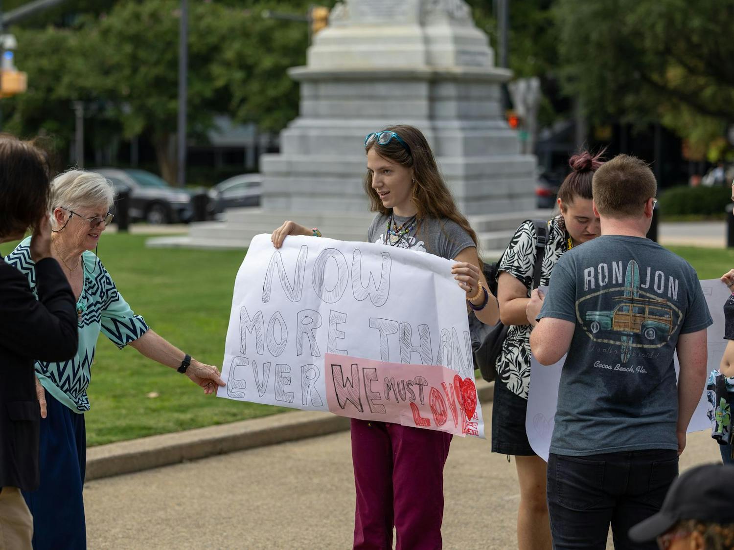 A demonstrator holds up a sign that says 'Now more than ever we must love' near the South Carolina Statehouse on Sept. 18, 2024. A peaceful rally was held on the north steps of the Statehouse to emphasize the importance of respect, inclusivity and peaceful opposition to hateful rhetoric.