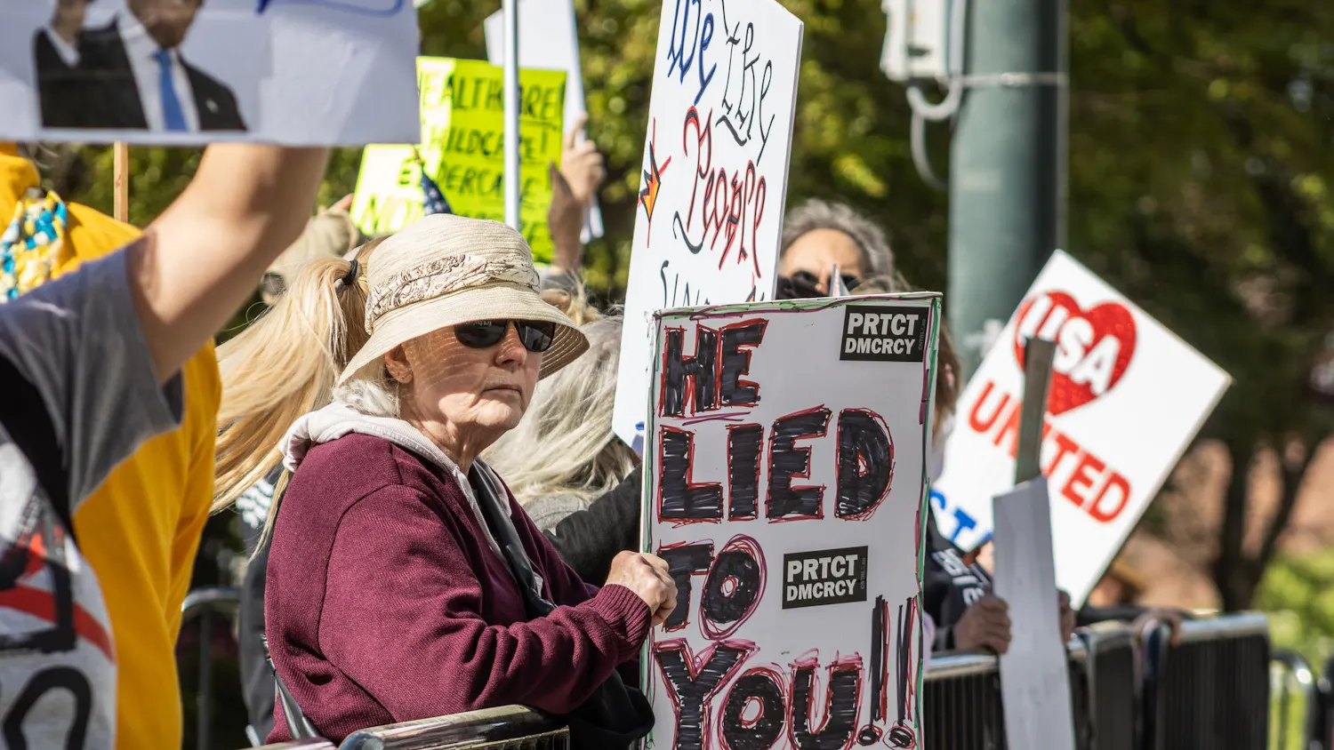 Individuals lift up their signs during the "No Kings" protest at the South Carolina State House on March 28, 2026. They spread their message to the cars that drive by on Gervais Street.