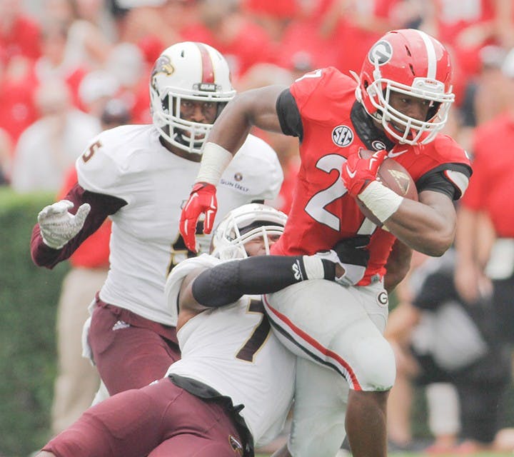 Georgia tailback Nick Chubb (27) runs the ball despite Louisiana-Monroe safety Mitch Lane (7) attempts to tackle him in the second half of an NCAA college football game against Louisiana-Monroe, on  Saturday, Sept. 5, 2015, at Sanford Stadium, in Athens, Georgia. (Photo/Taylor Carpenter)
