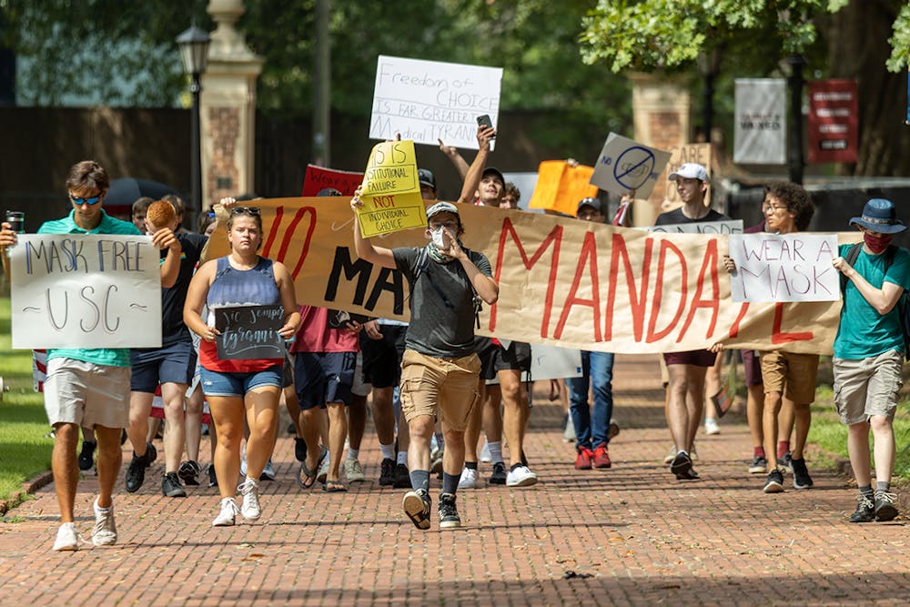 <p>The USC Turning Point USA chapter protests on the Horseshoe over the mask mandate while the Carolina Socialists counterprotest. The mask mandate was put in place by interim university President Harris Pastides on Aug. 18, 2021.</p>